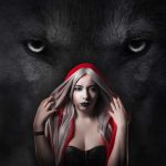 Woman in a red hooded cloak poses confidently with a looming wolf in the dark background.