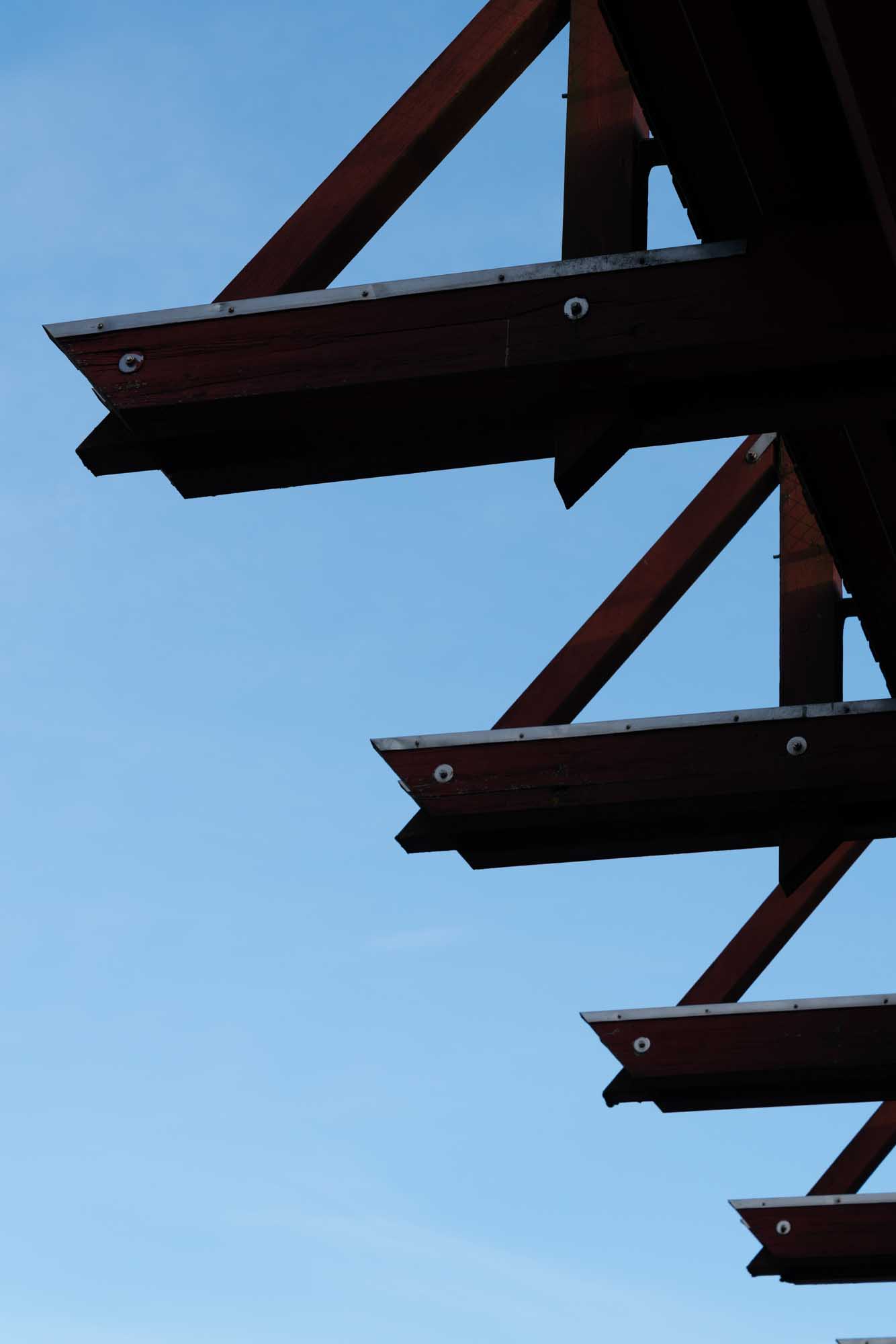 Steel beams extending against a clear blue sky, highlighting architectural structure.