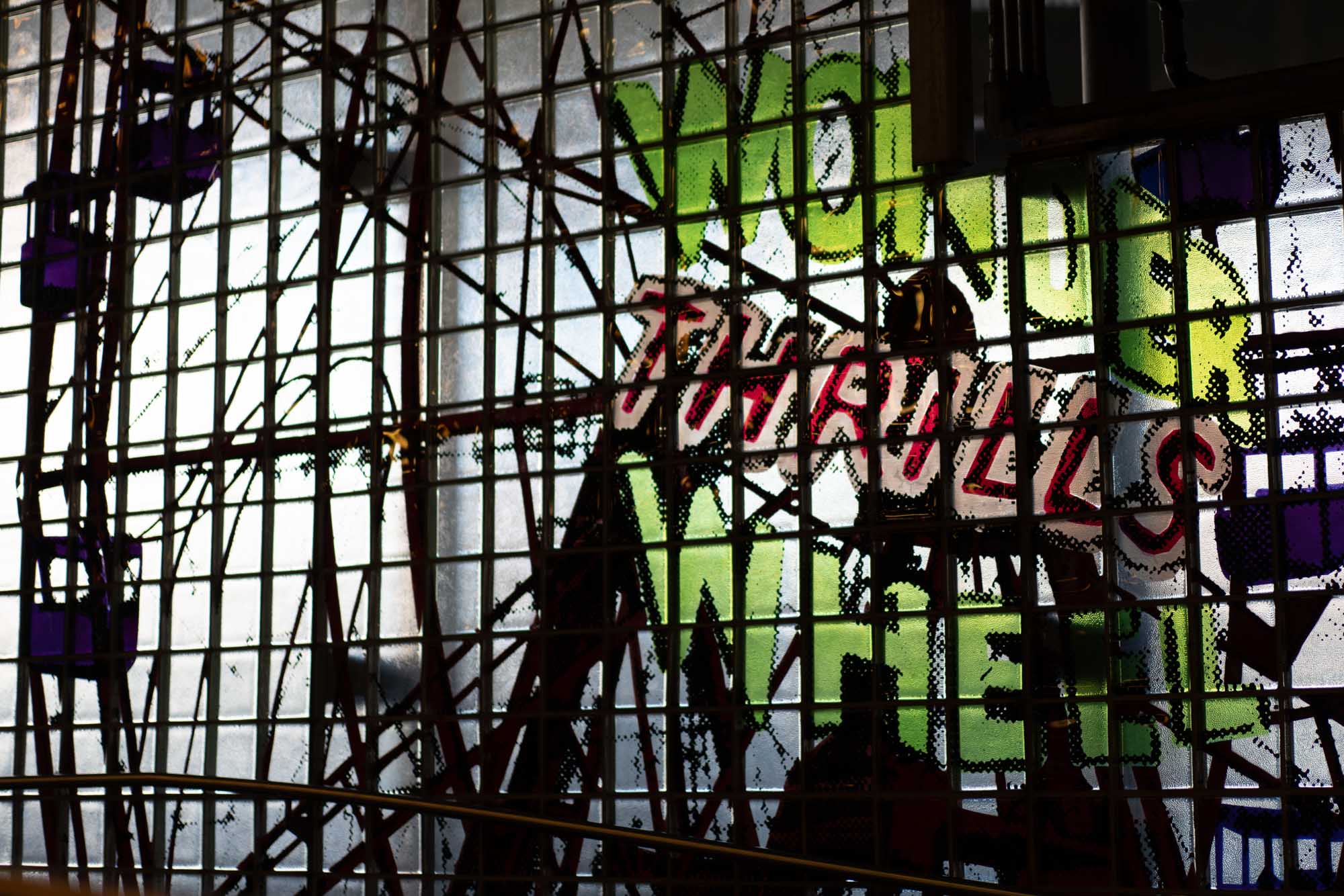Stained glass art with vibrant green and red text Thrills on a grid pattern, creating an industrial aesthetic.