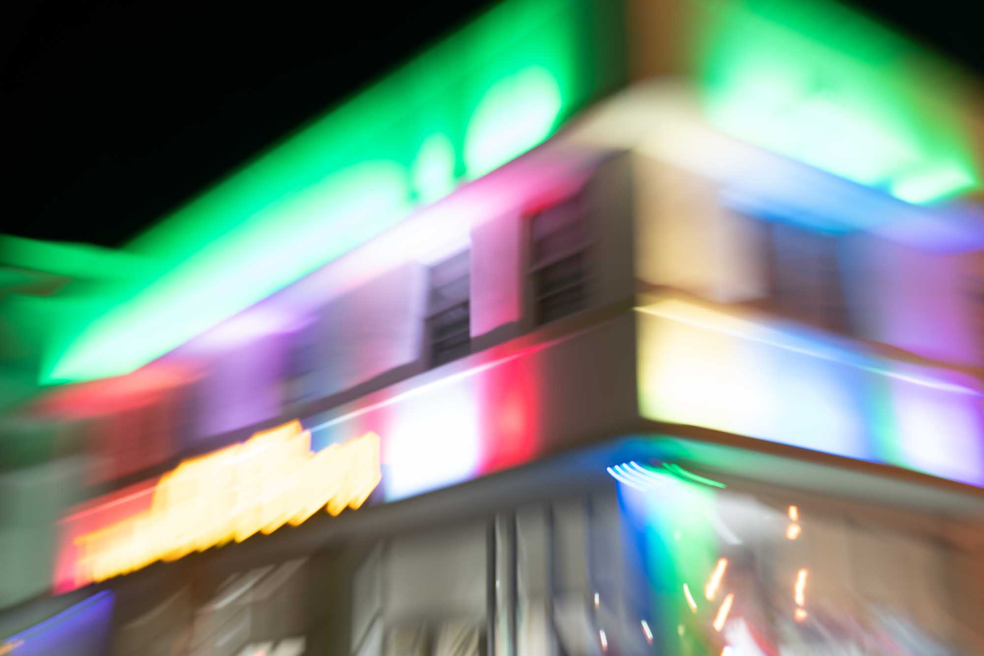 Blurry colorful lights on a building at night, creating a vibrant, abstract effect.