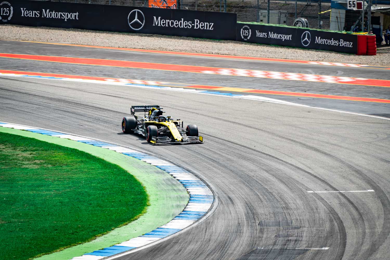 Formula 1 car racing on a track with vibrant turns, under Mercedes-Benz banners.