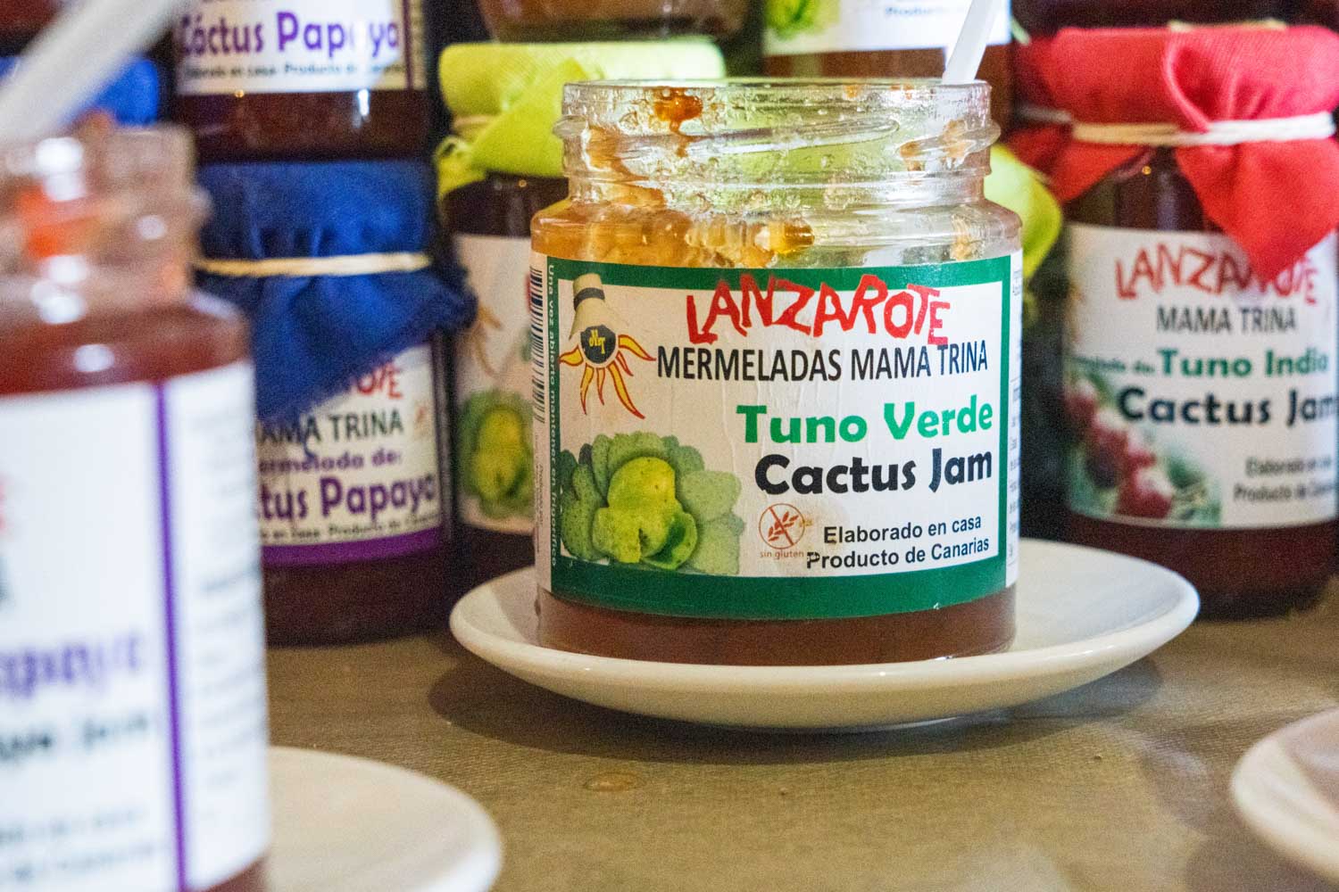 Tuno Verde cactus jam jars labeled Lanzarote Mermeladas Mama Trina on display, assorted jams in background.