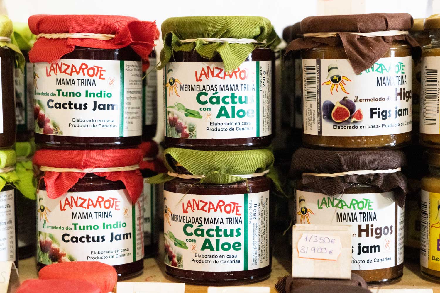 Jars of Lanzarote jam with cactus, aloe, and fig flavors, labeled Mama Trina, displayed on a shelf.