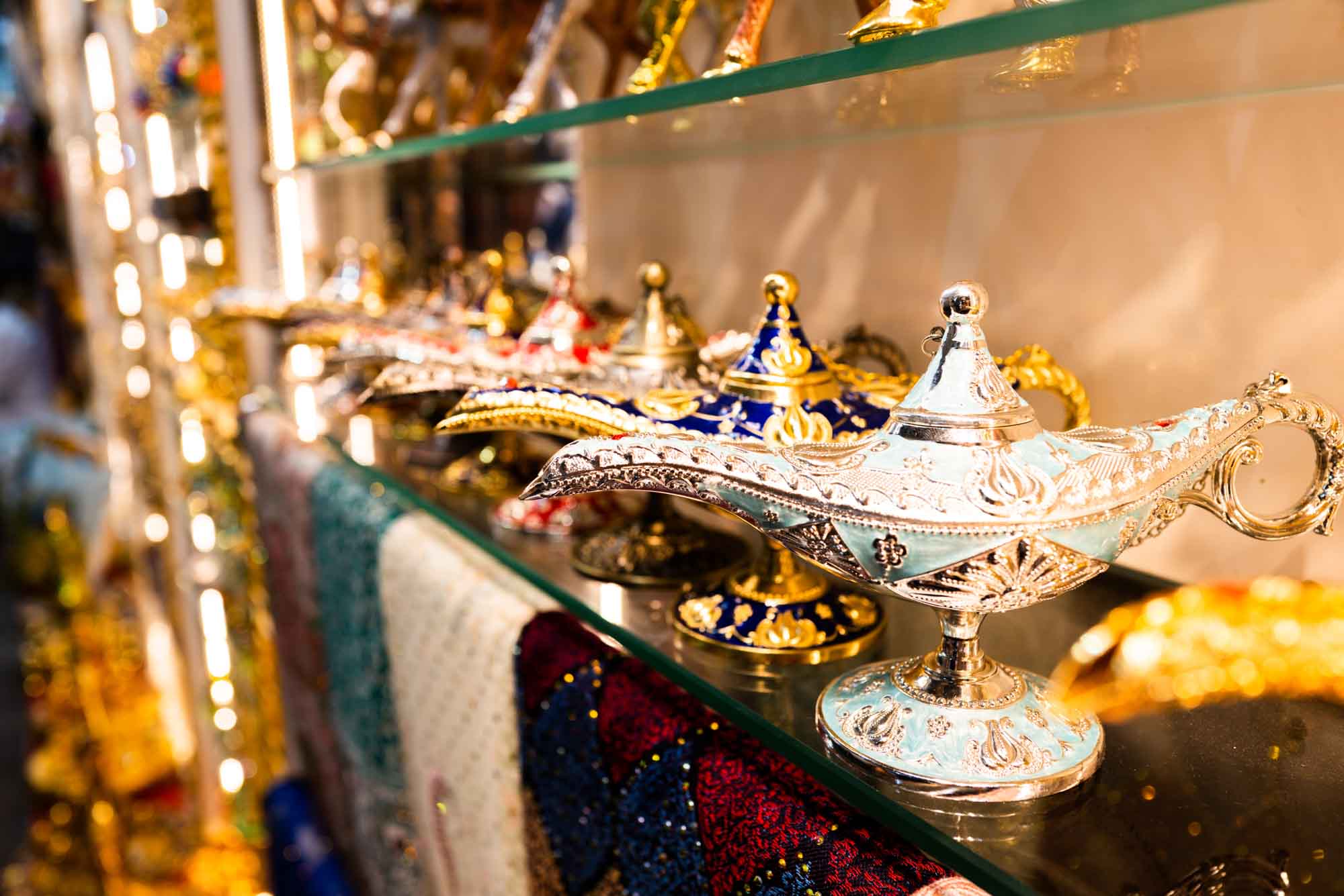 Colorful decorative genie lamps on display in a well-lit market shelf.