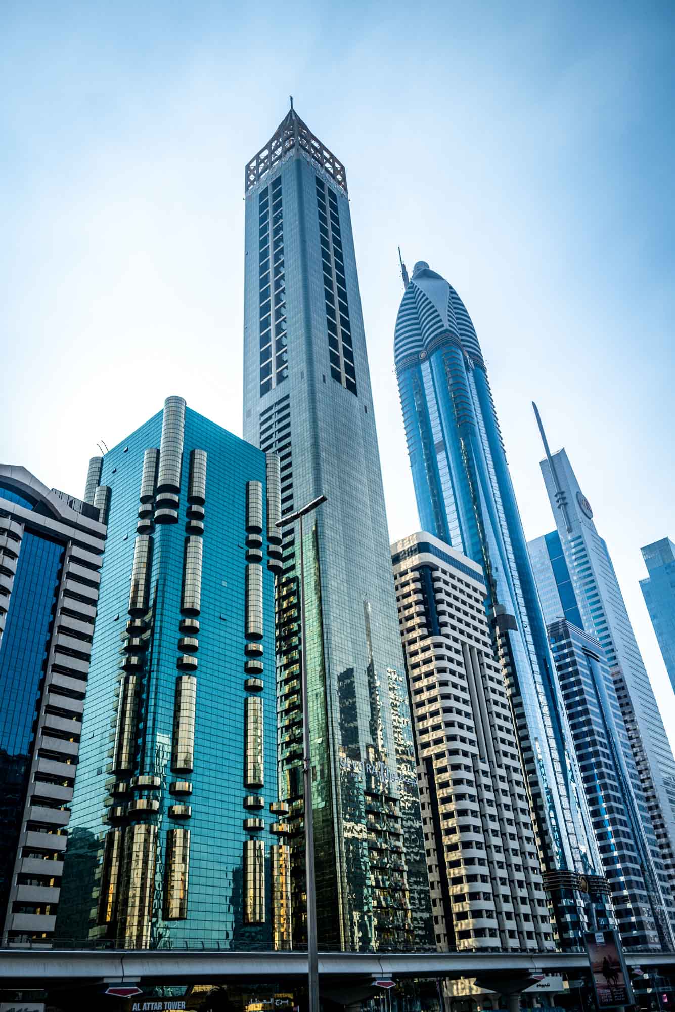 Modern skyscrapers in a cityscape, reflecting blue sky, showcasing urban architecture and futuristic design.