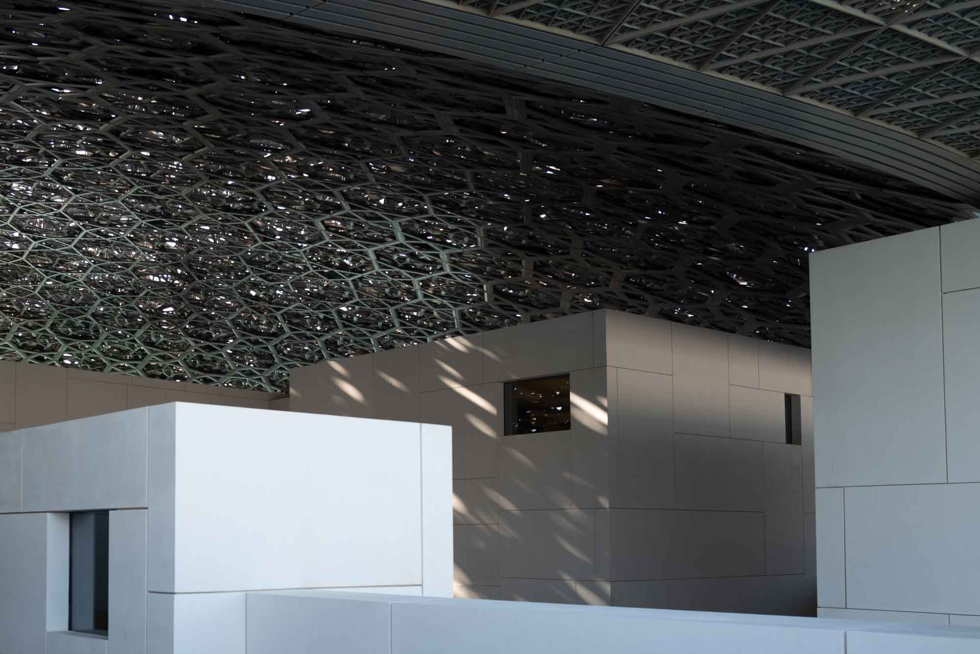 Modern architectural design with intricate lattice ceiling and geometric structures.