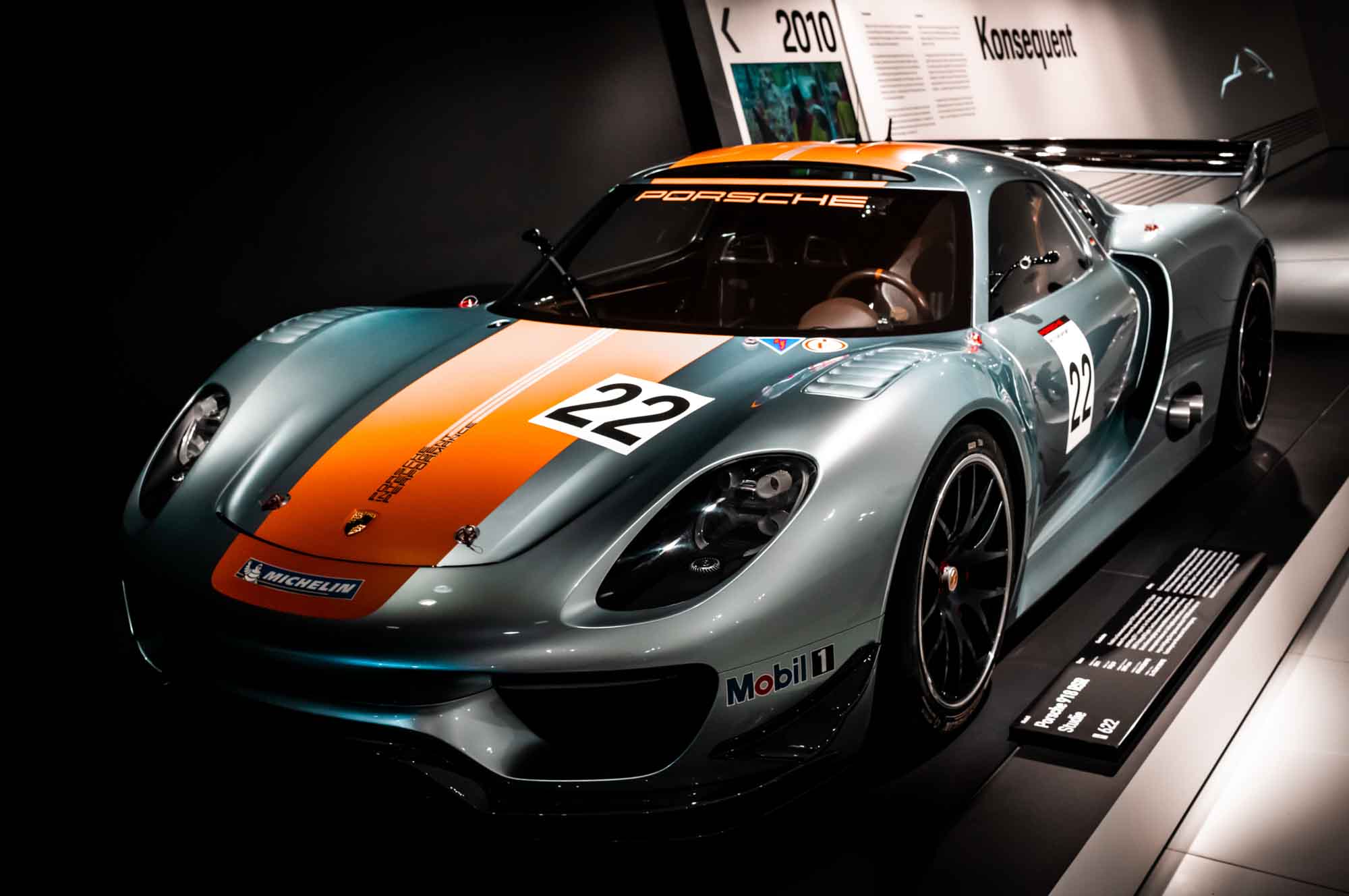 Sleek Porsche race car with number 22, displayed in a museum setting, exhibiting stylish design and performance.