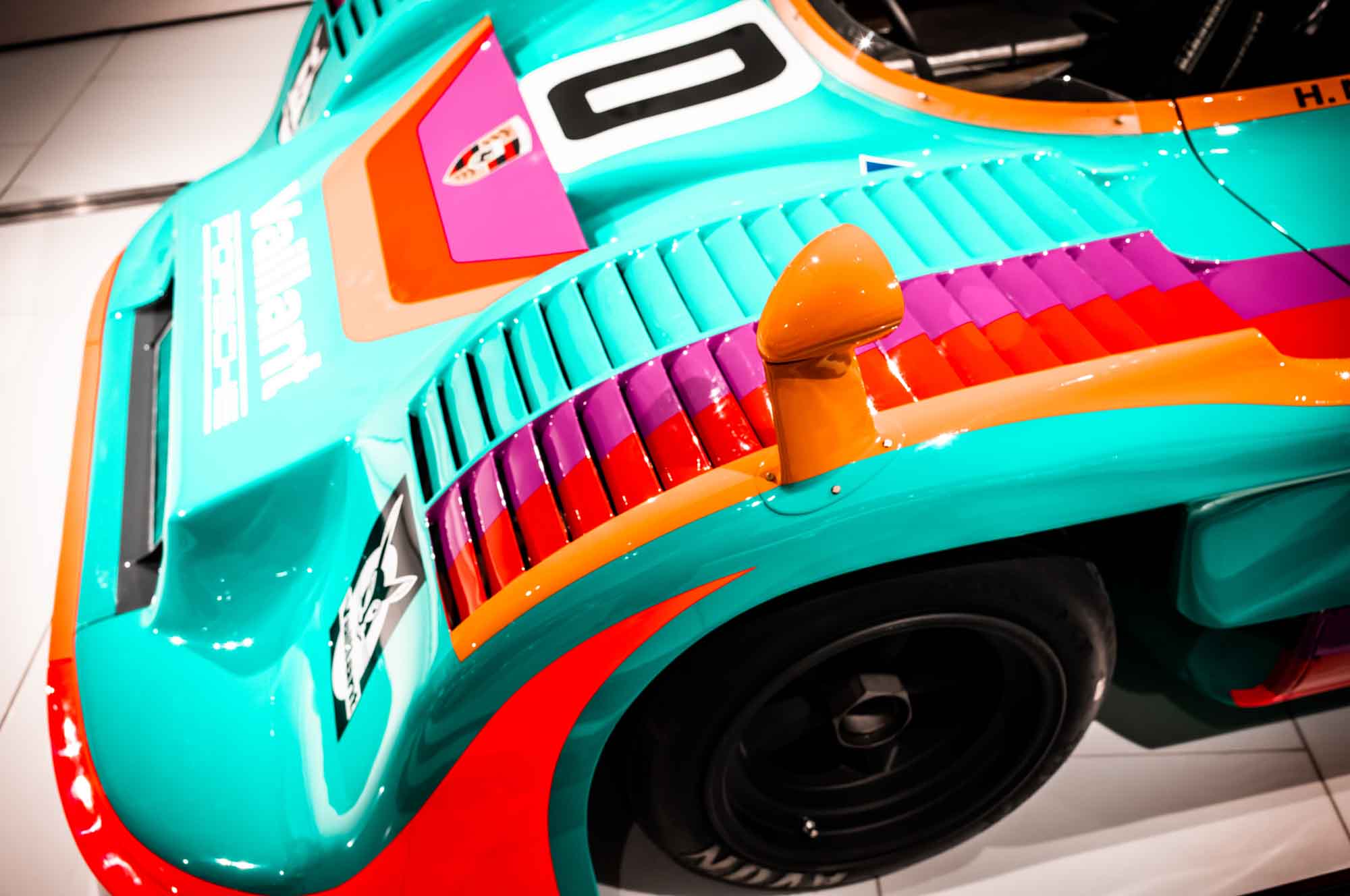Colorful vintage race car with bold stripes and number zero on display, showcasing retro design and vibrant livery.