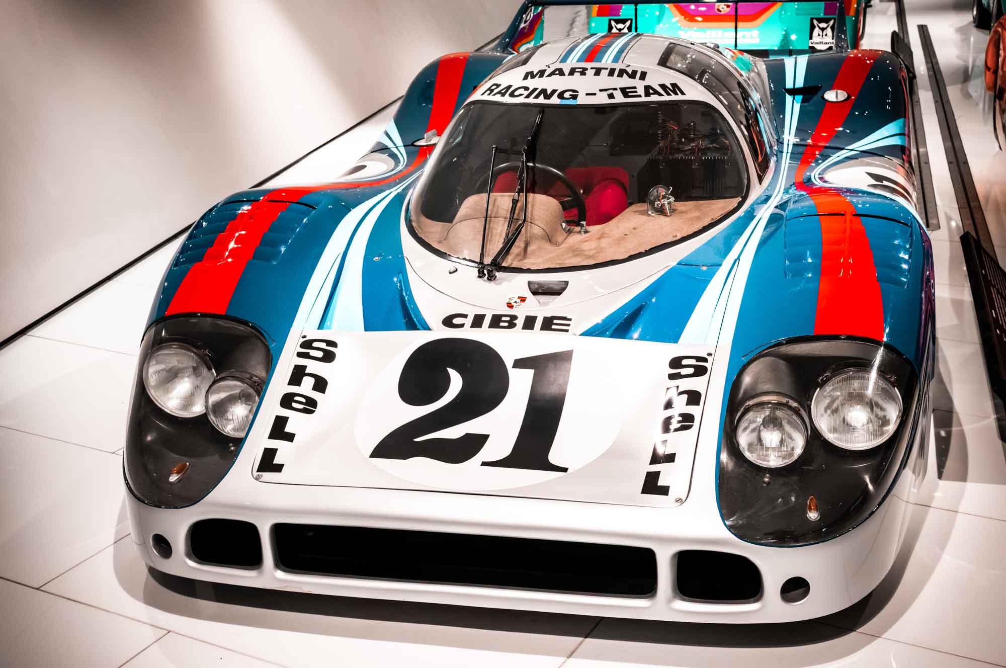 Vintage race car with Martini Racing livery on display, showcasing sleek design and vibrant colors.