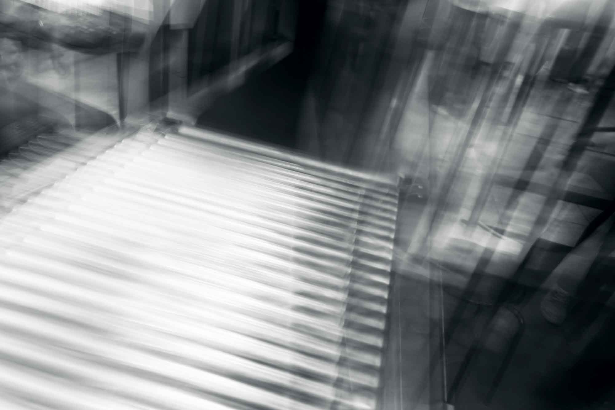 Abstract motion blur of industrial conveyor belt in monochrome tones.