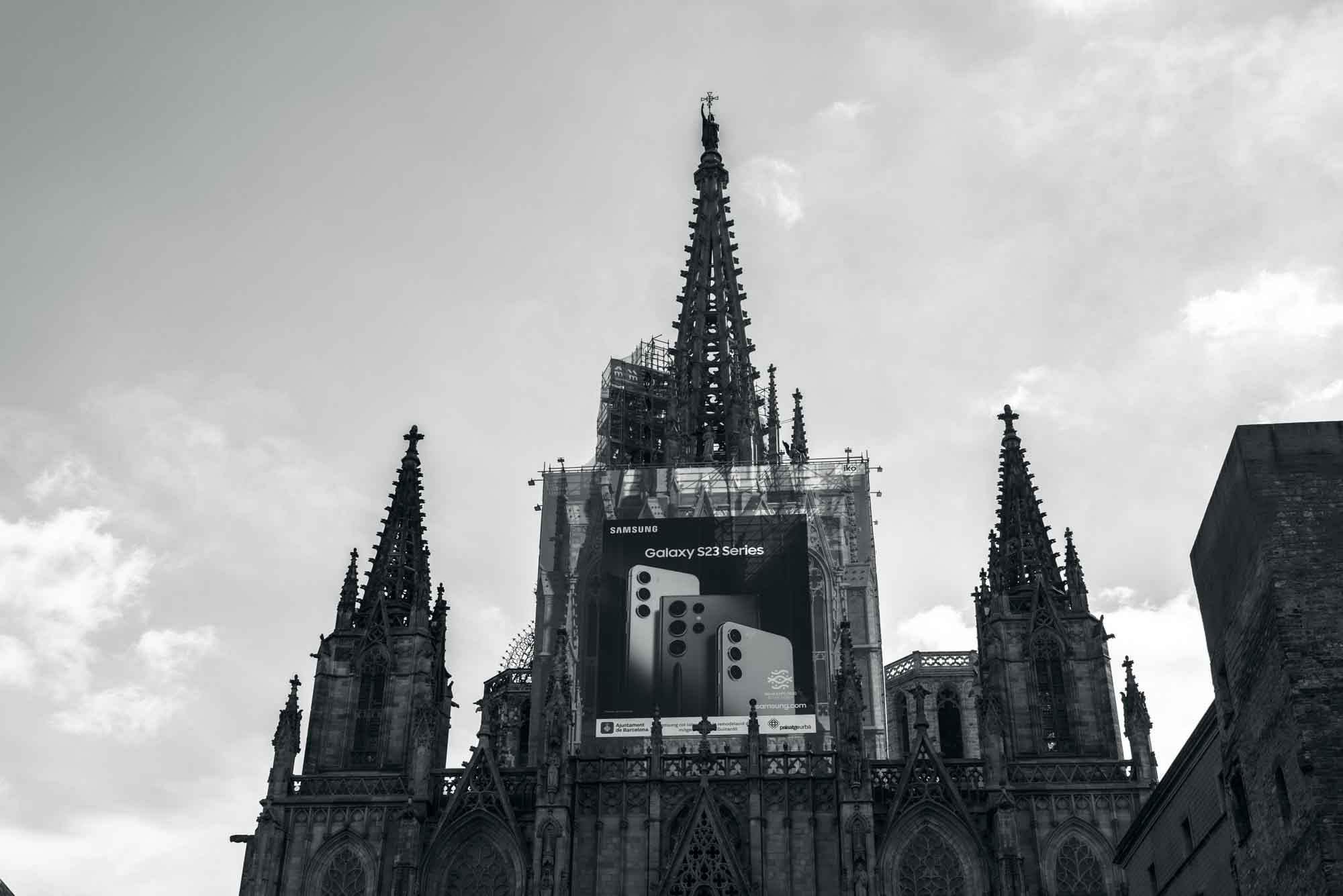 Gothic cathedral with Samsung Galaxy S23 advertisement, blending modern tech with historic architecture.