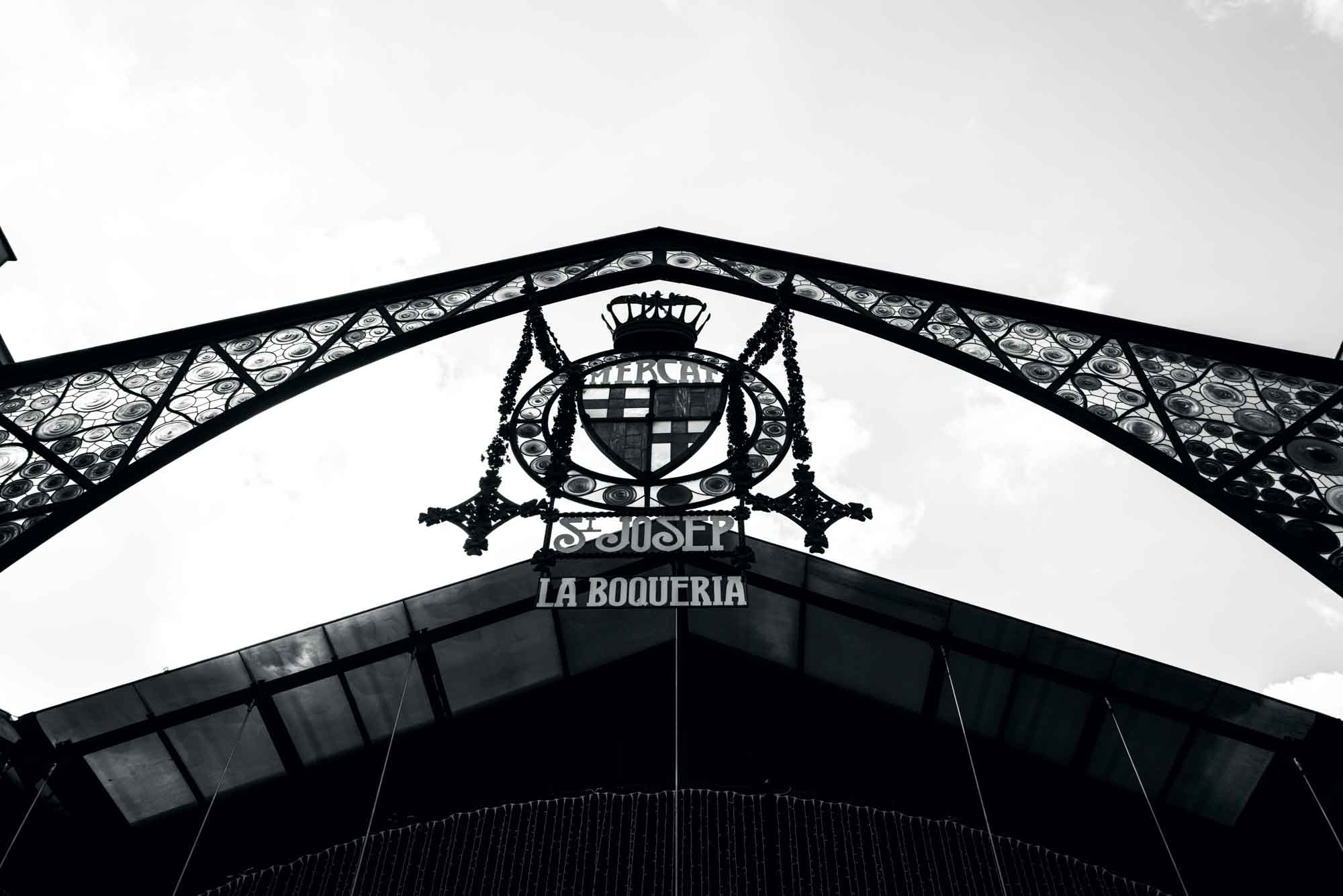 Ornate entrance to Mercat de Sant Josep La Boqueria, iconic market in Barcelona, black and white photo.