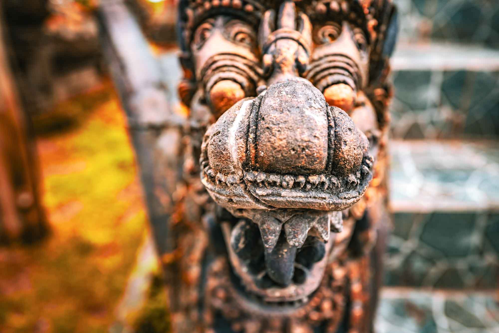 Close-up of ancient stone lion sculpture with vivid colors and intricate details during autumn.