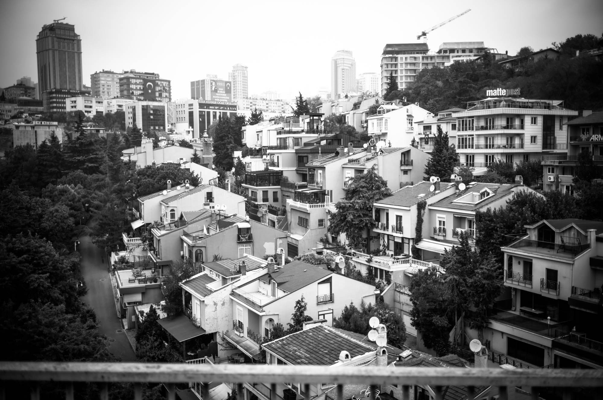 Black and white cityscape of densely packed buildings and skyscrapers in the background.