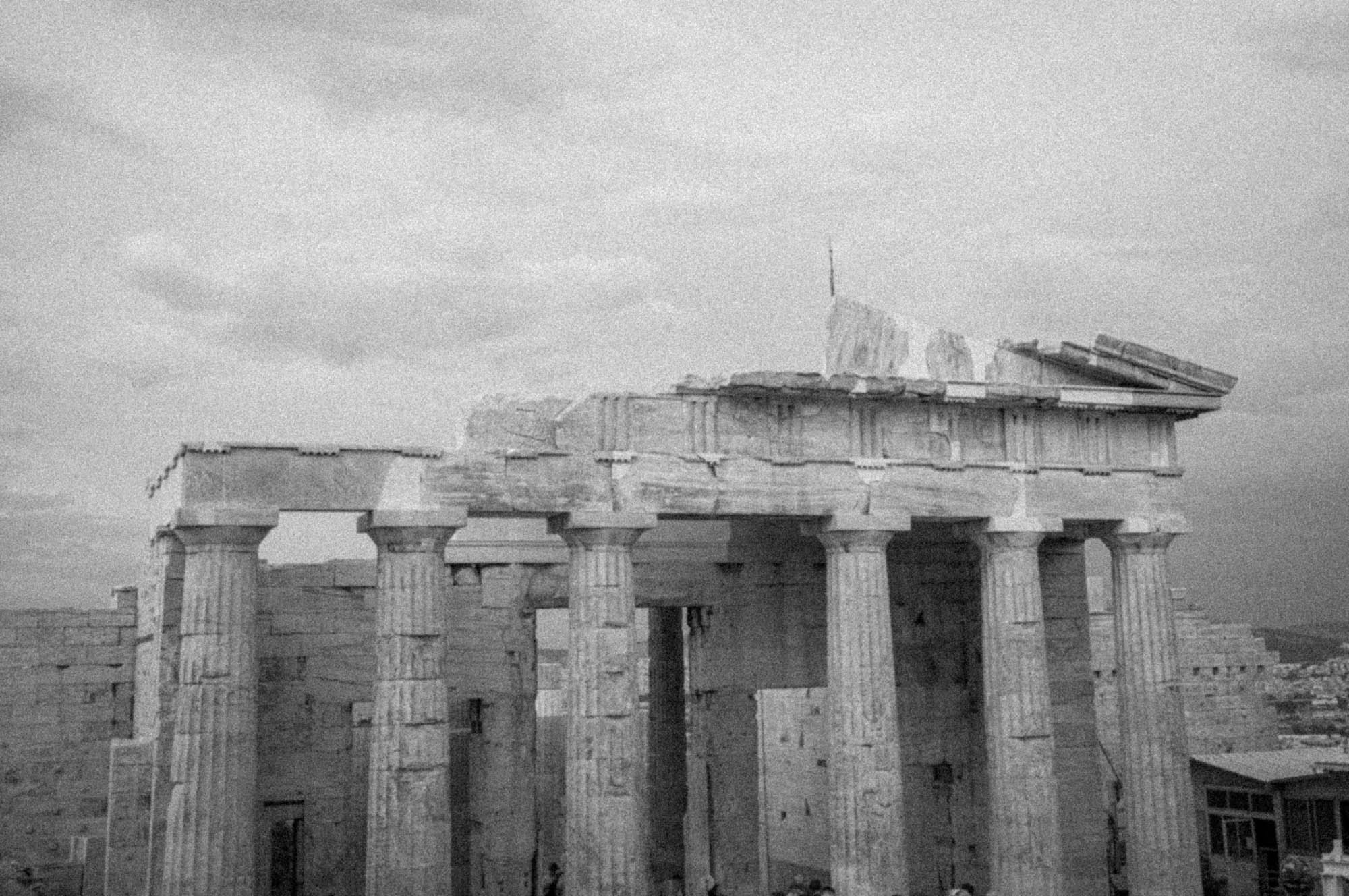 Black and white image of the ancient Greek Parthenon, featuring iconic columns and architectural details.
