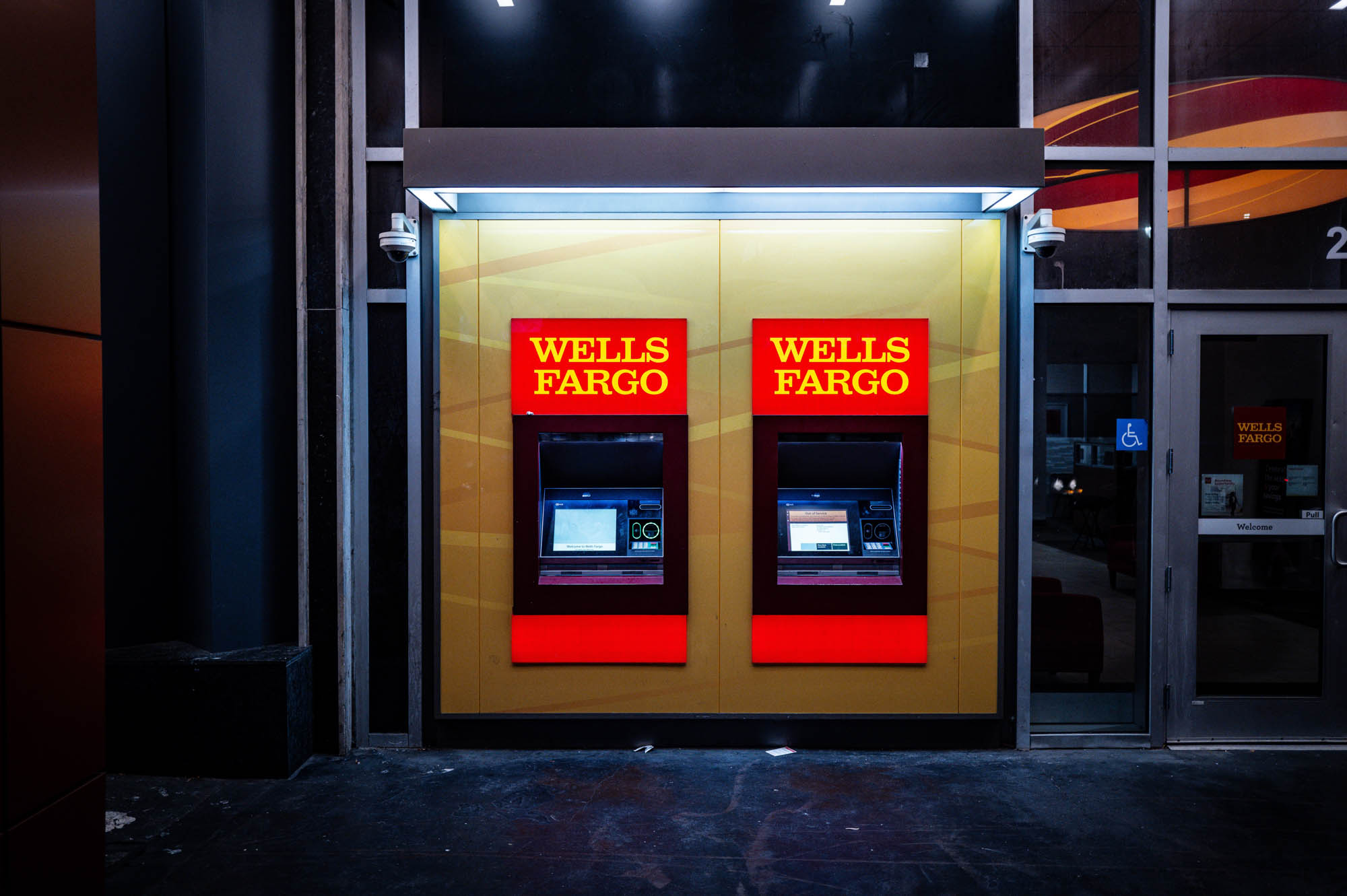 Two Wells Fargo ATMs illuminated at night in an urban setting.