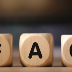 Wooden blocks spelling FAQ on a table, representing frequently asked questions concept.
