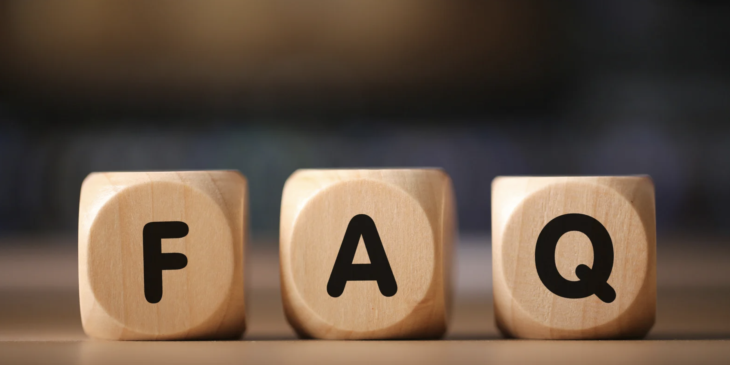 Wooden blocks spelling FAQ on a table, representing frequently asked questions concept.