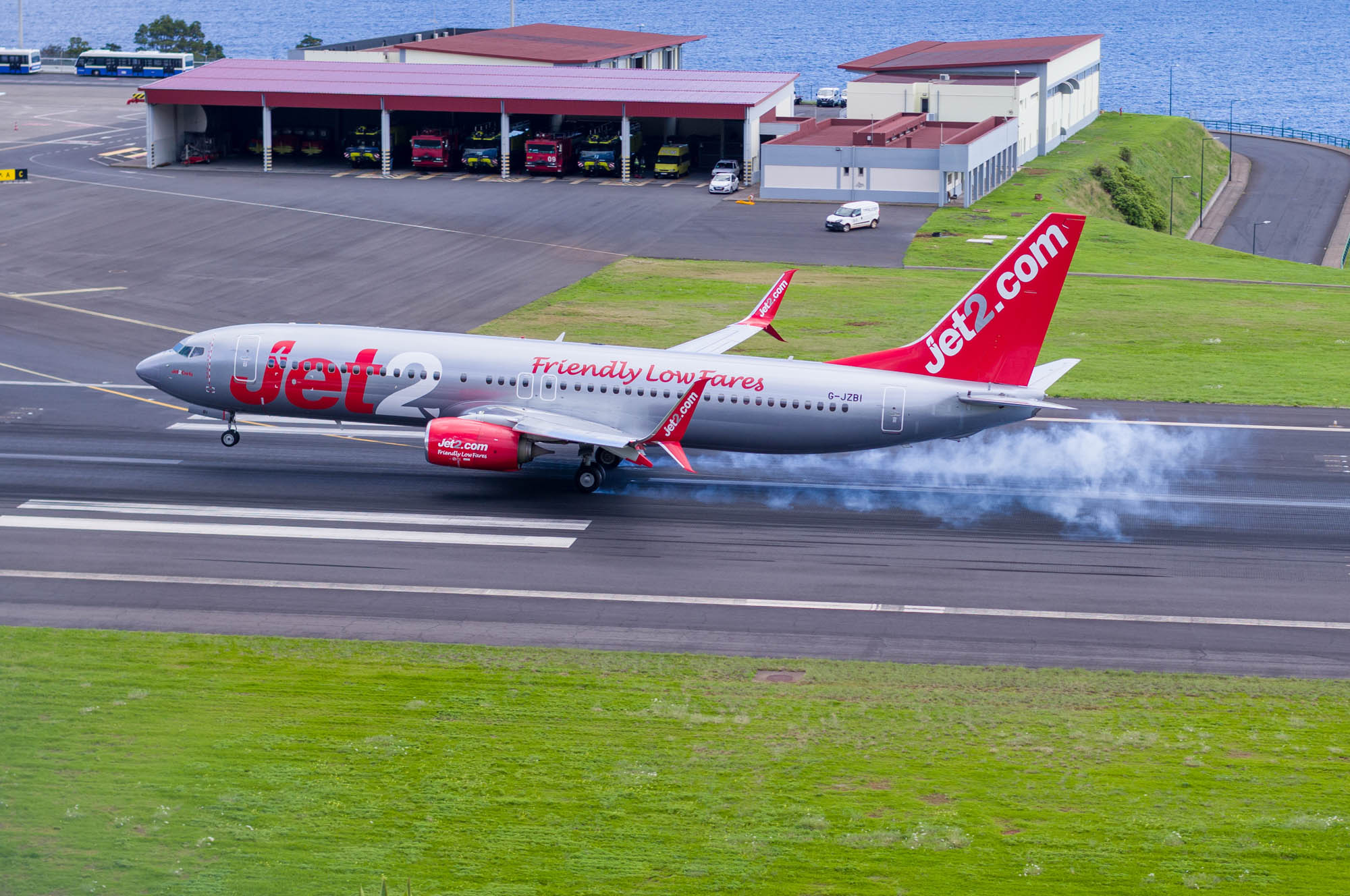 Jet2 airplane landing on runway with smoke from tires, showcasing its low fares and reliable service.