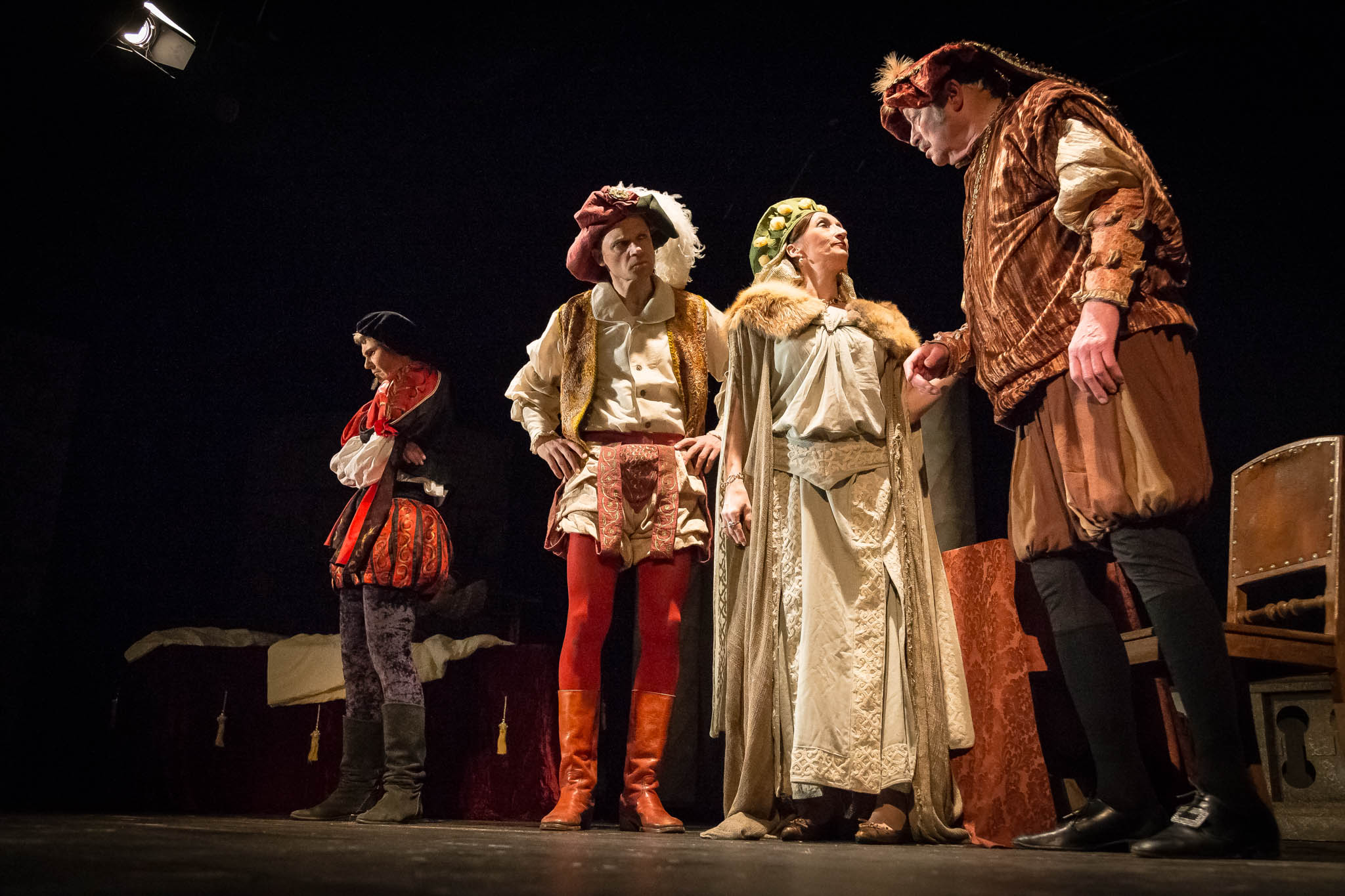 Actors in Renaissance costumes performing a dramatic scene on stage.