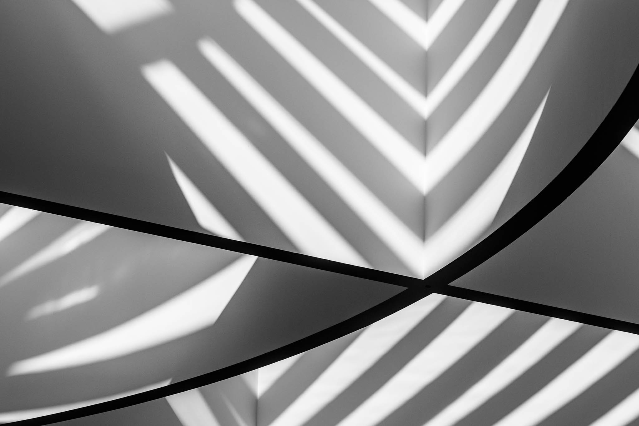 Abstract black and white lines and shadows forming geometric patterns on a wall.