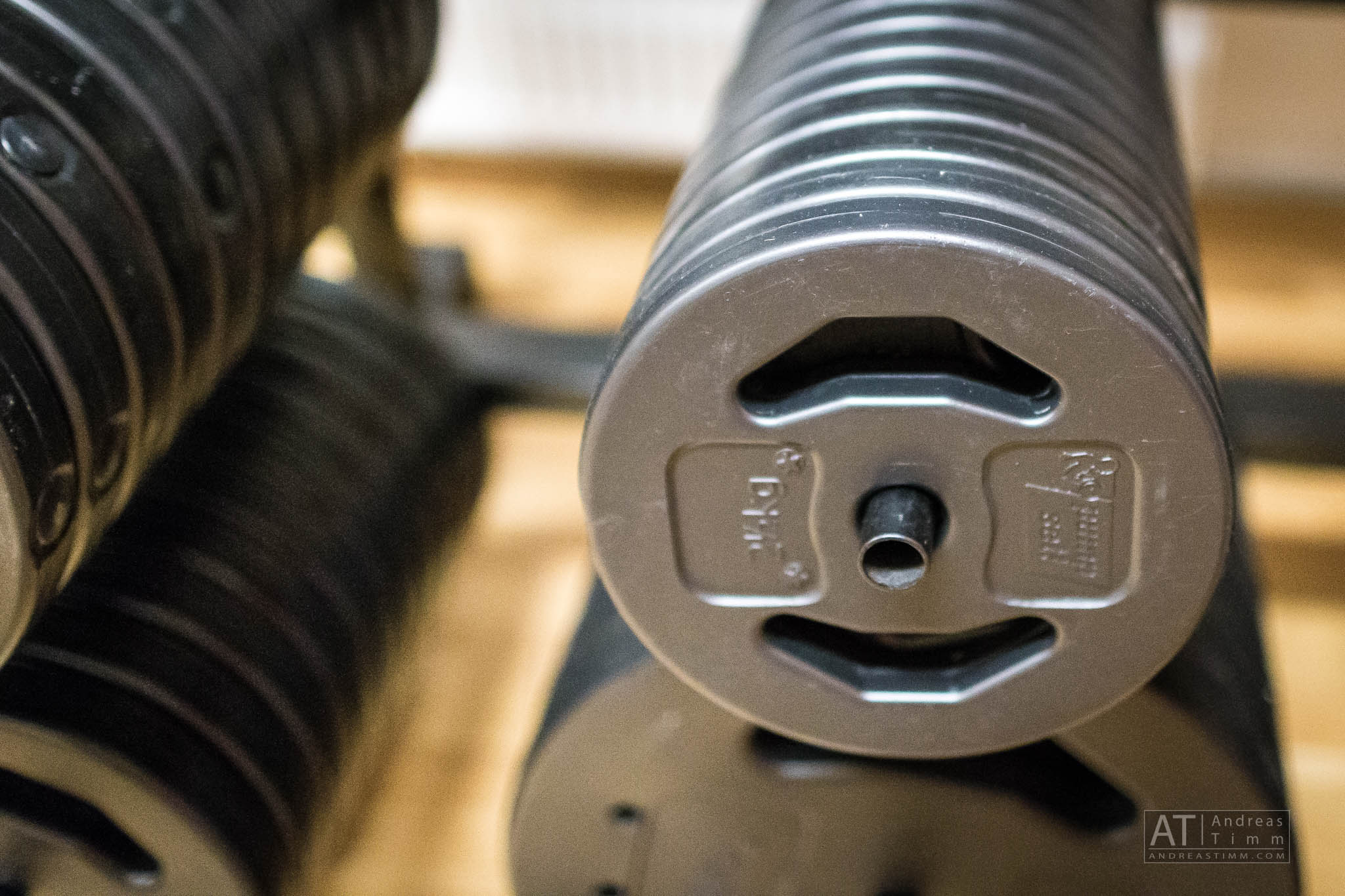 Stacked gym weight plates on a rack ready for workouts.