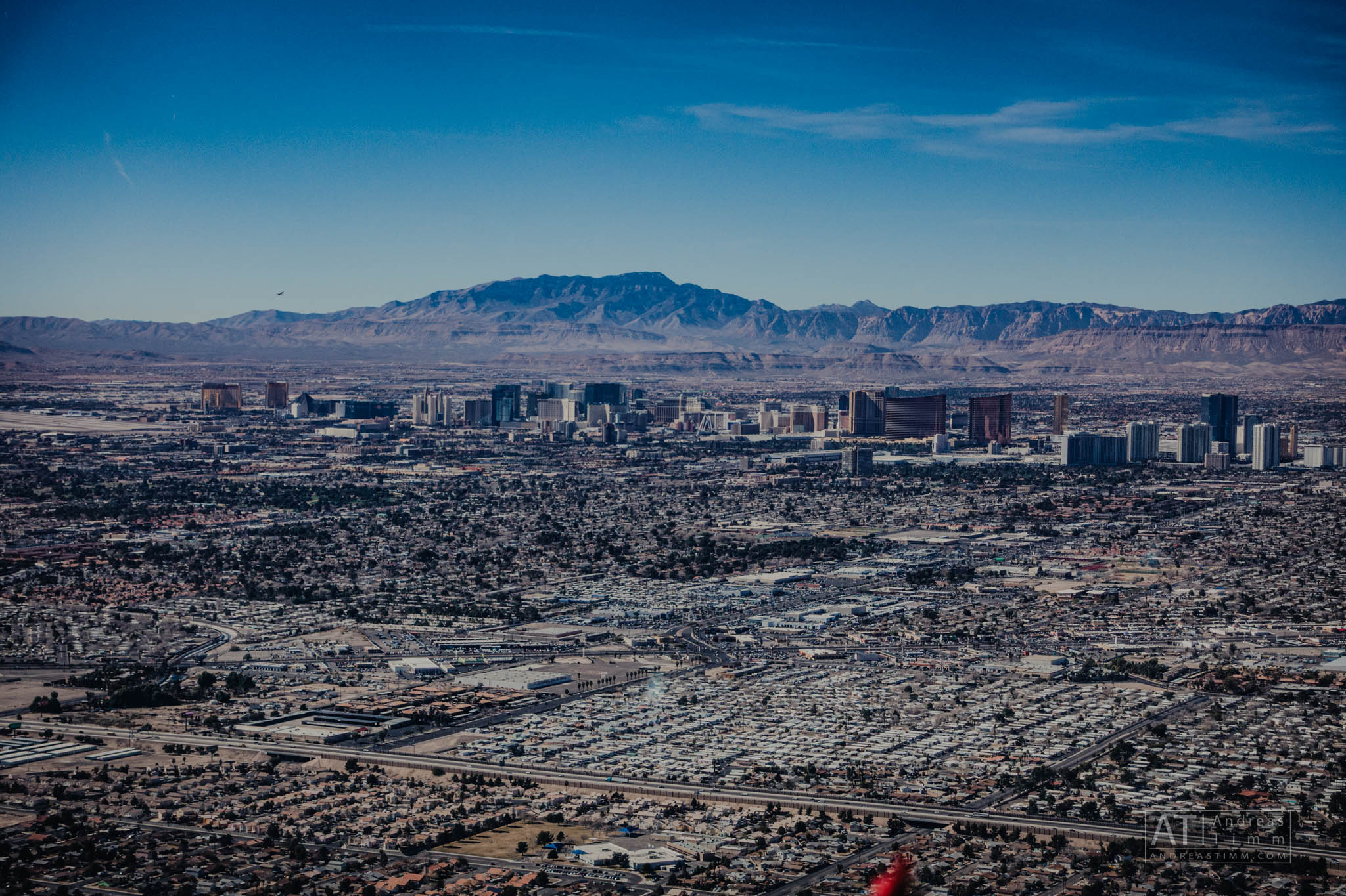Aerial view of Las Vegas skyline with mountains in the background on a clear day.