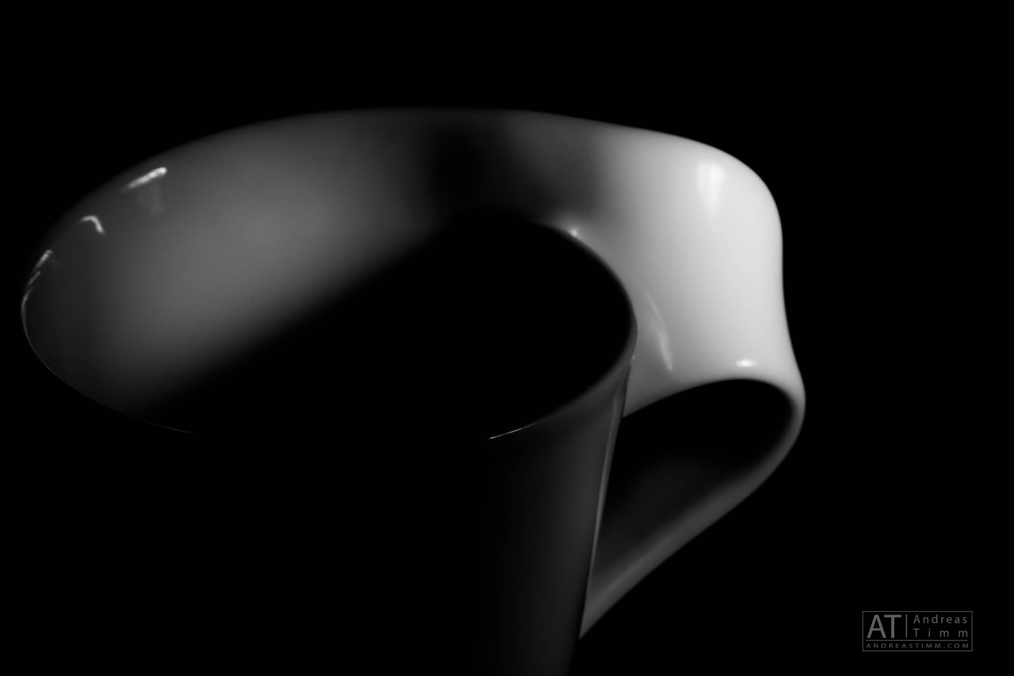Abstract black and white photo of a cup handle with dramatic lighting and shadows.