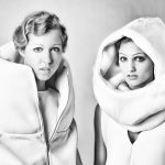 Black and white photo of two women in avant-garde fashion with large, structured collars and futuristic hairstyles.