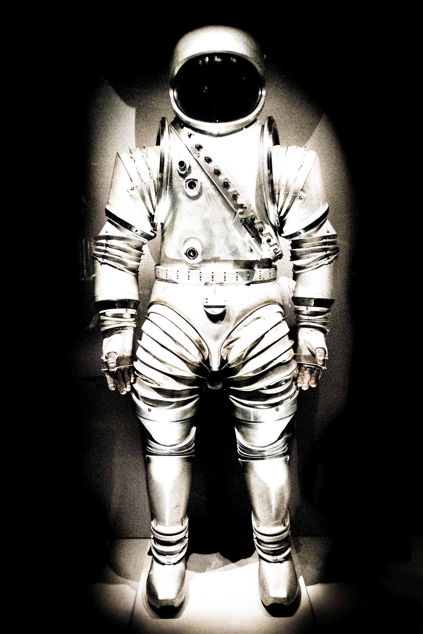 Metallic space suit with helmet, displayed against dark background, emphasizing futuristic design and intricate details.