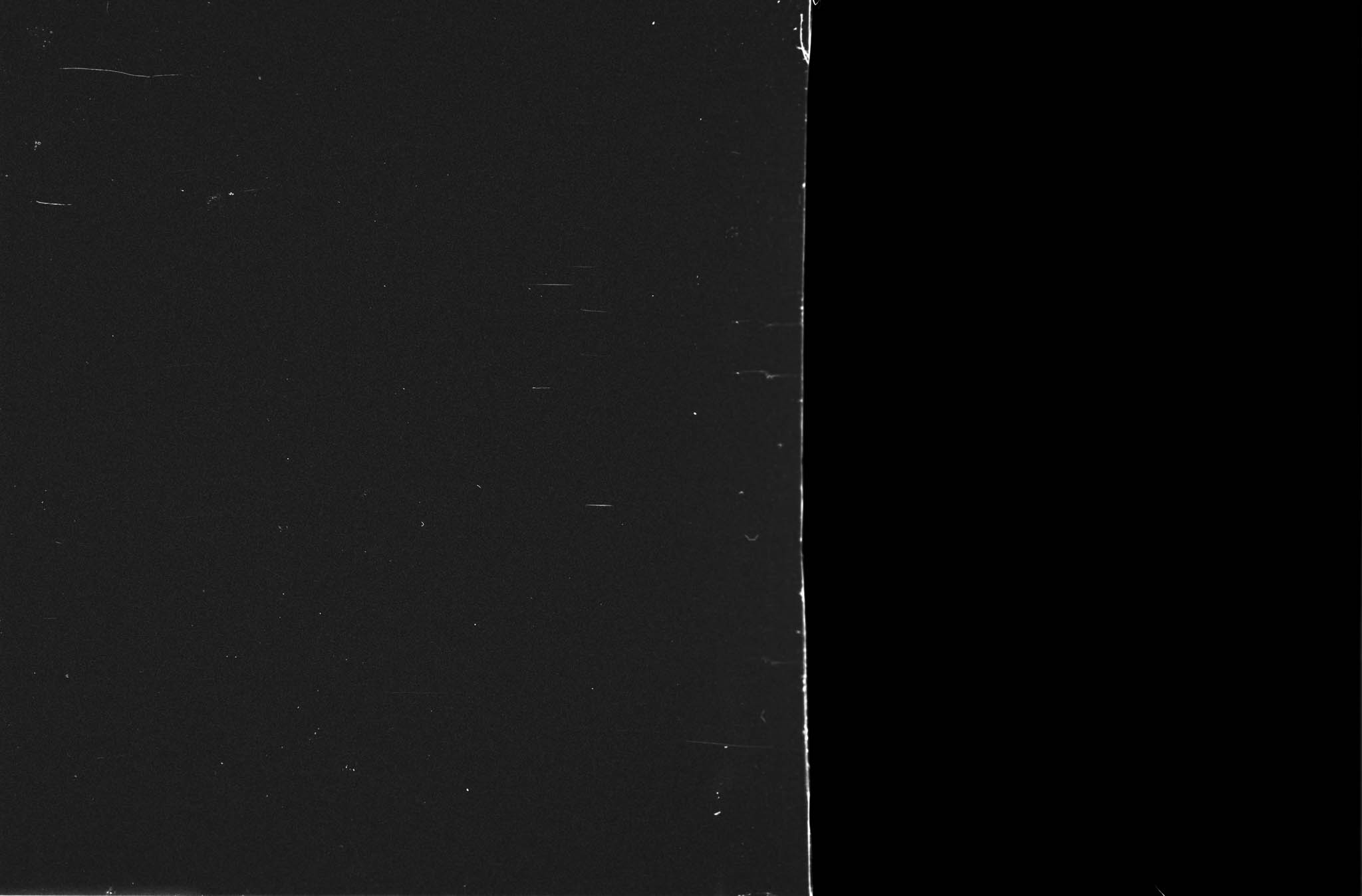 Black and white scratched film texture with a vertical seam.