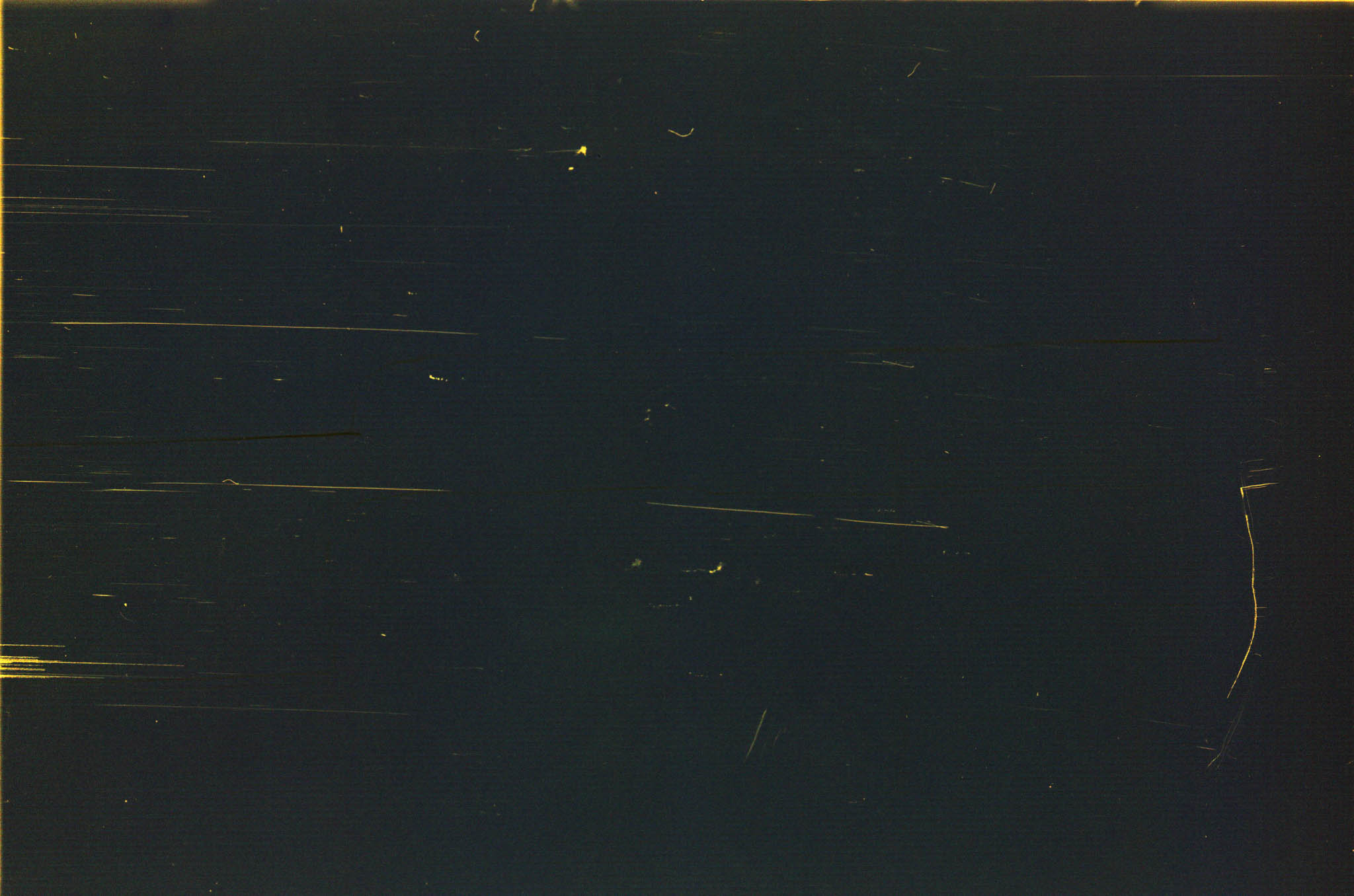 Dark abstract background with thin, light-colored scratches and lines scattered across the surface.