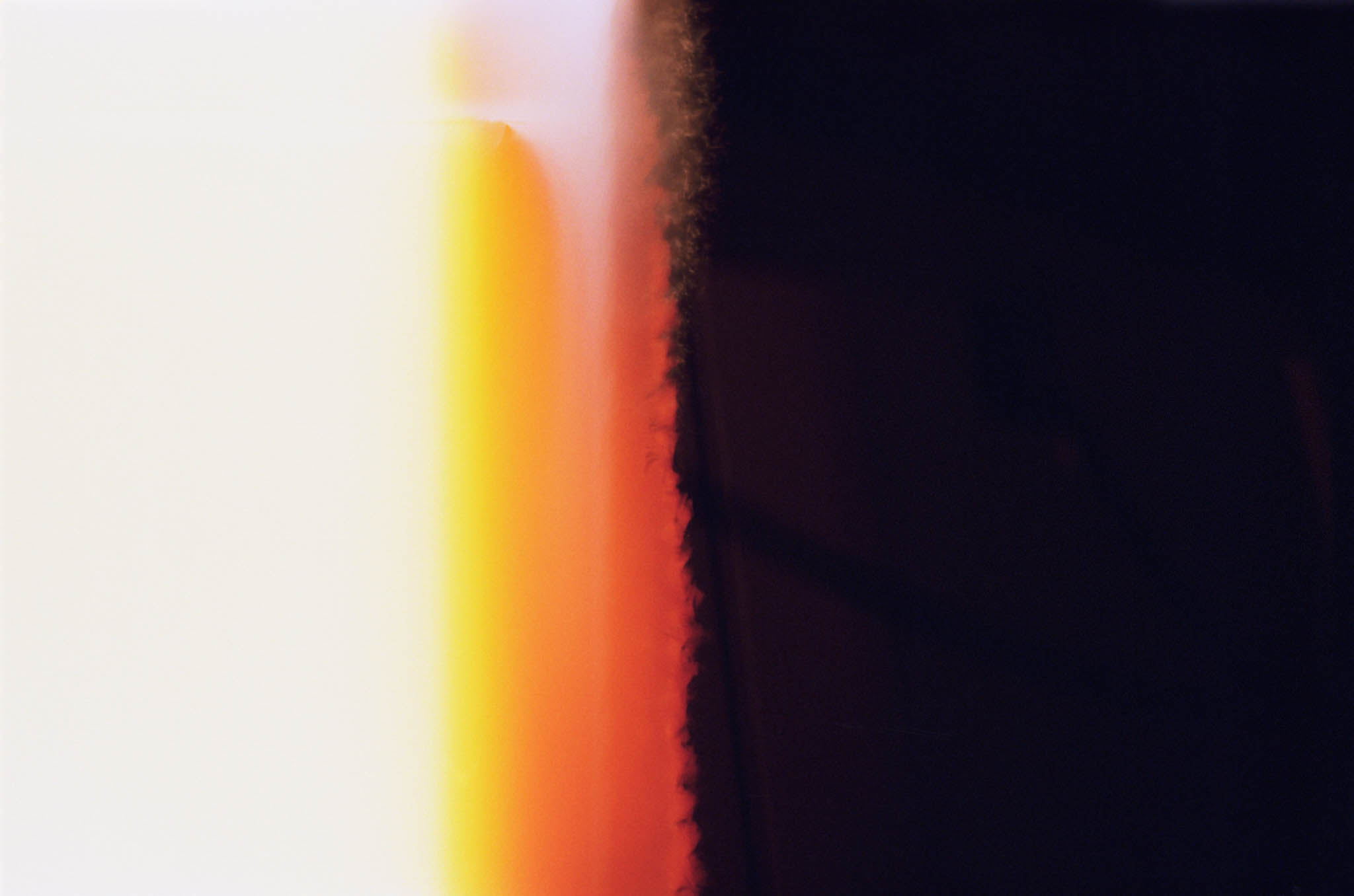 Abstract image with gradient of bright white to deep orange, transitioning into dark black on the right side.