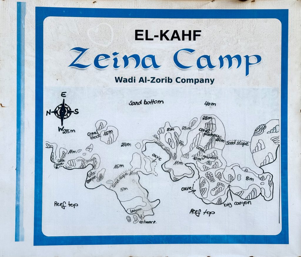 Hand-drawn diving map of El-Kahf Zeina Camp, showing reef tops, sand slopes, and depth measurements with compass.