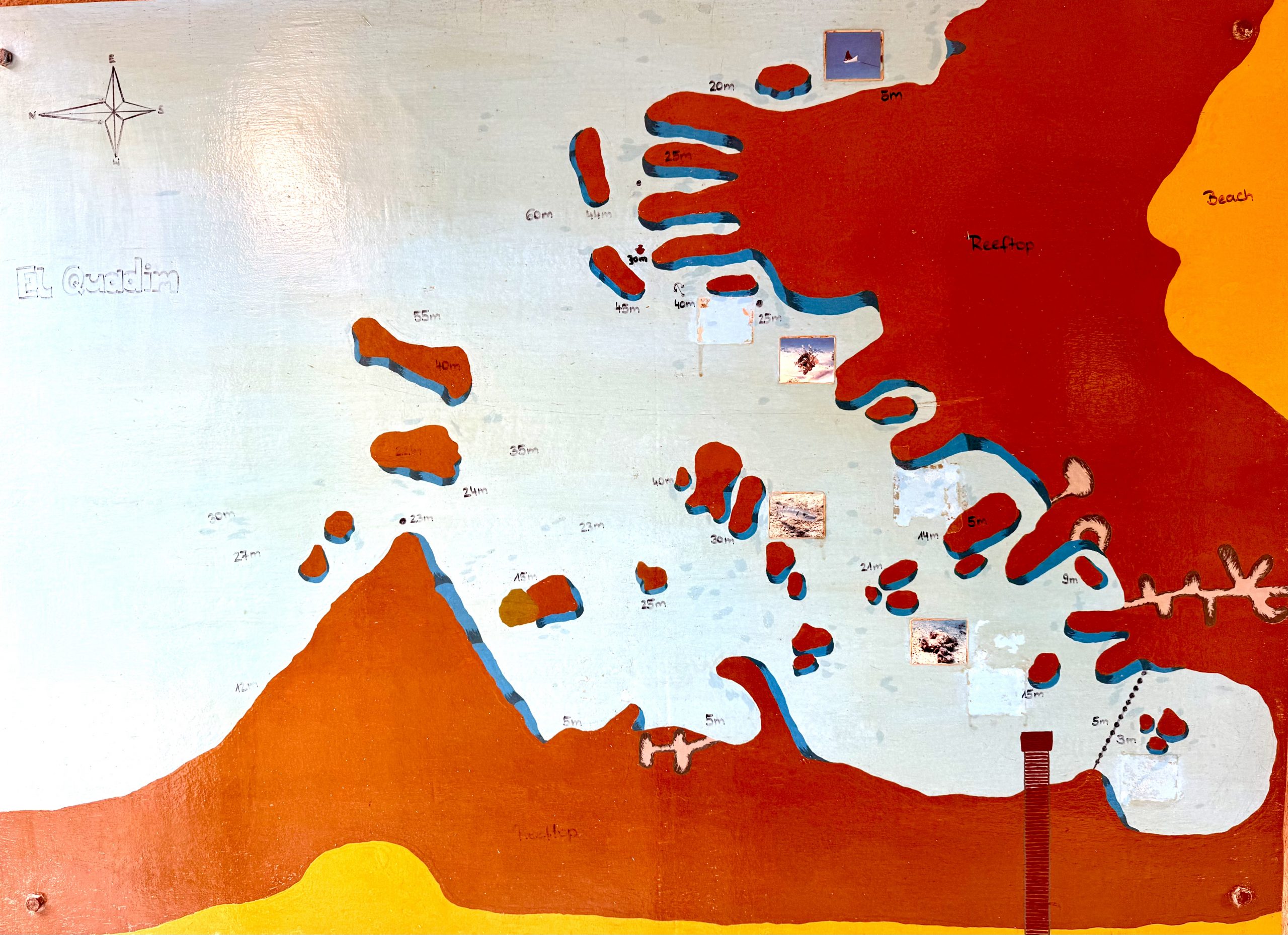 Hand-painted map of El Quadim, showing reefs, depths, and compass rose on a colorful background. Map copyright is by EXTRA DIVERS El Quseir