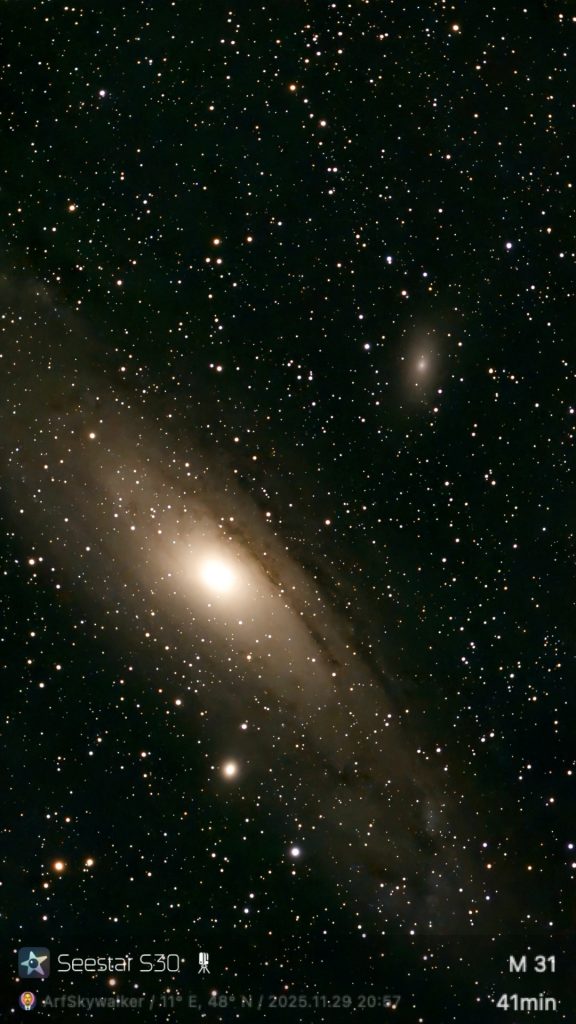 Bright Andromeda Galaxy M31 with scattered stars in deep space sky.