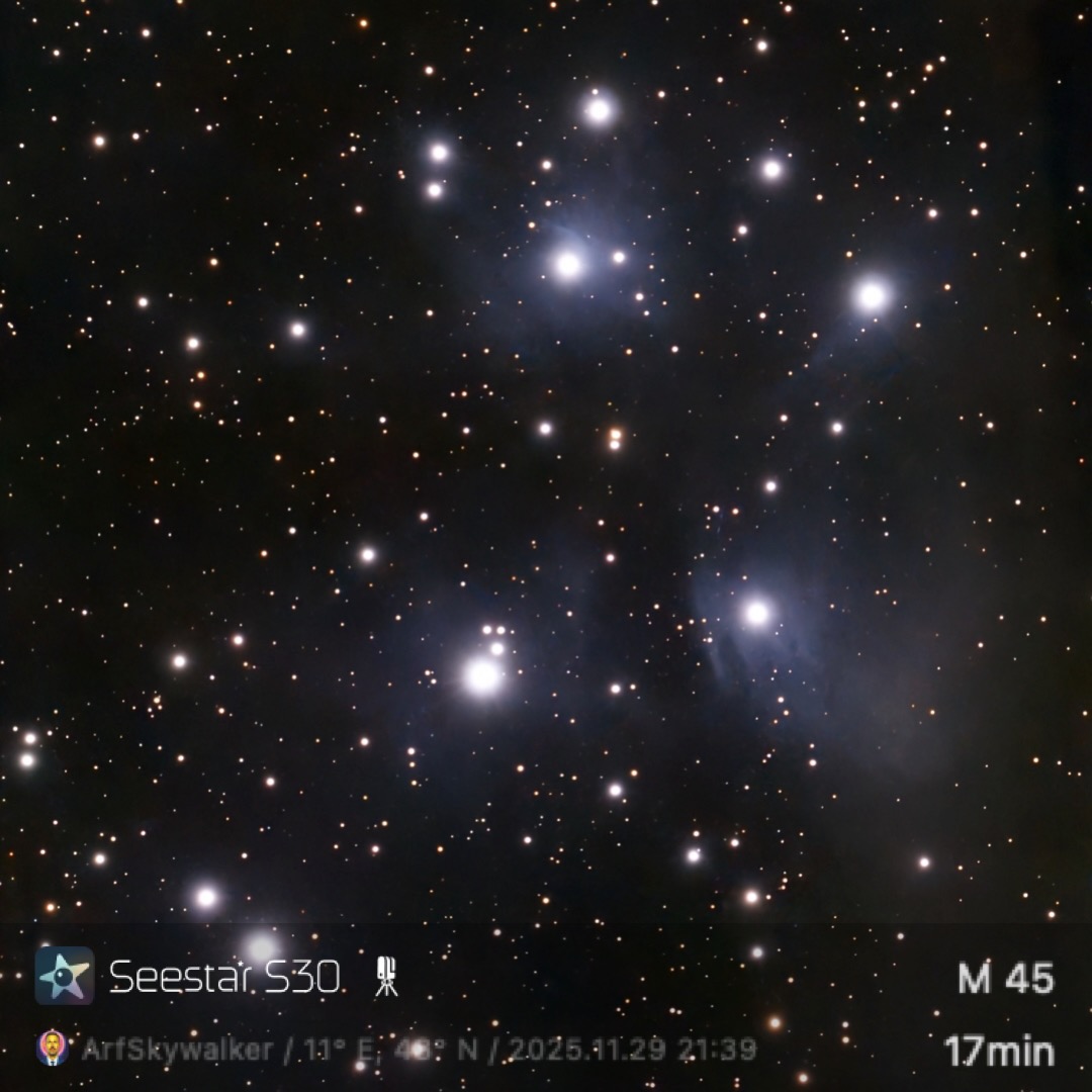 Bright night sky capturing the Pleiades star cluster, M45, with numerous glowing stars against a dark backdrop.